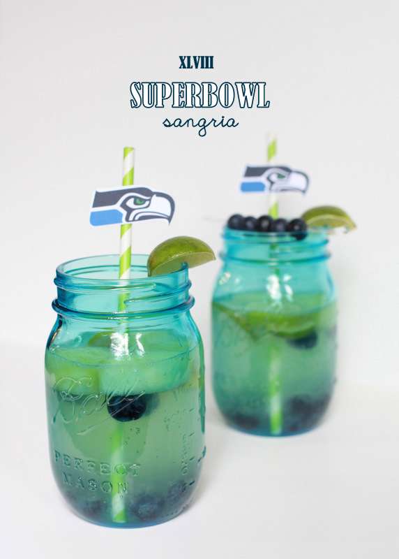 Super Bowl Sangria recipe with blueberries, melon, and lime slices in a glass