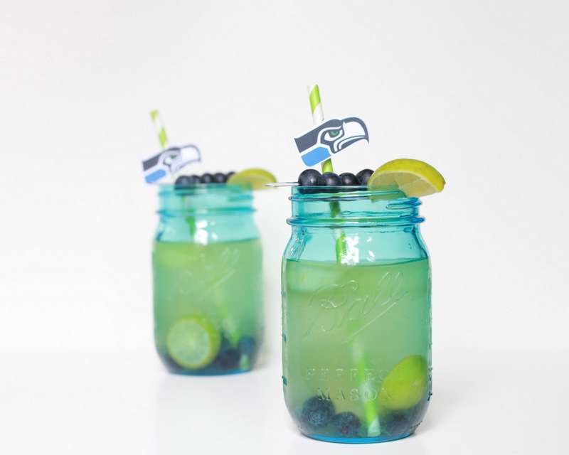 Super Bowl Sangria recipe with blueberries, melon, and lime slices in a glass