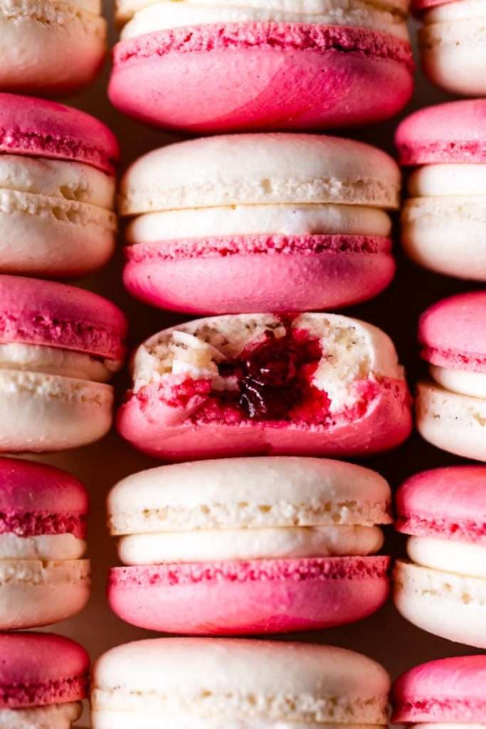 Cranberry vanilla bean French macarons filled with creamy vanilla buttercream and cranberry jam.