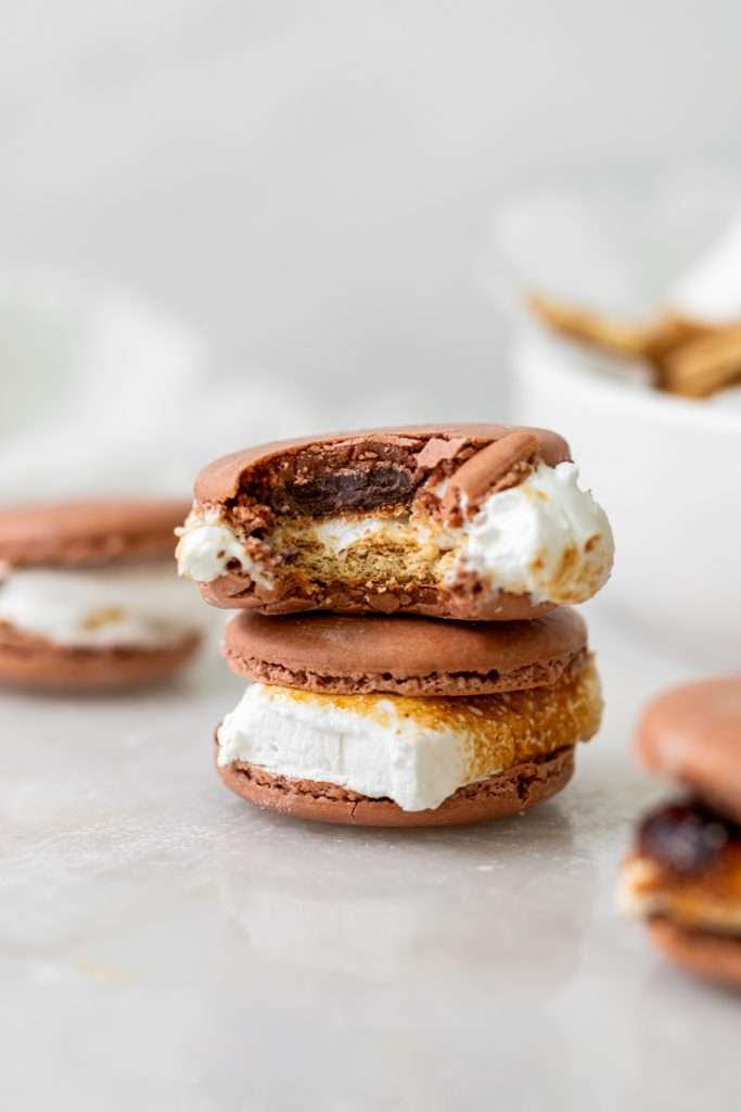 Don't let summer come to an end without making a batch of these S'mores macarons. Complete with chocolate macaron shells, homemade marshamallows, graham crackers and dark chocolate, they are the ultimate s'mores dessert for the season! Dairy free and gluten free option included.