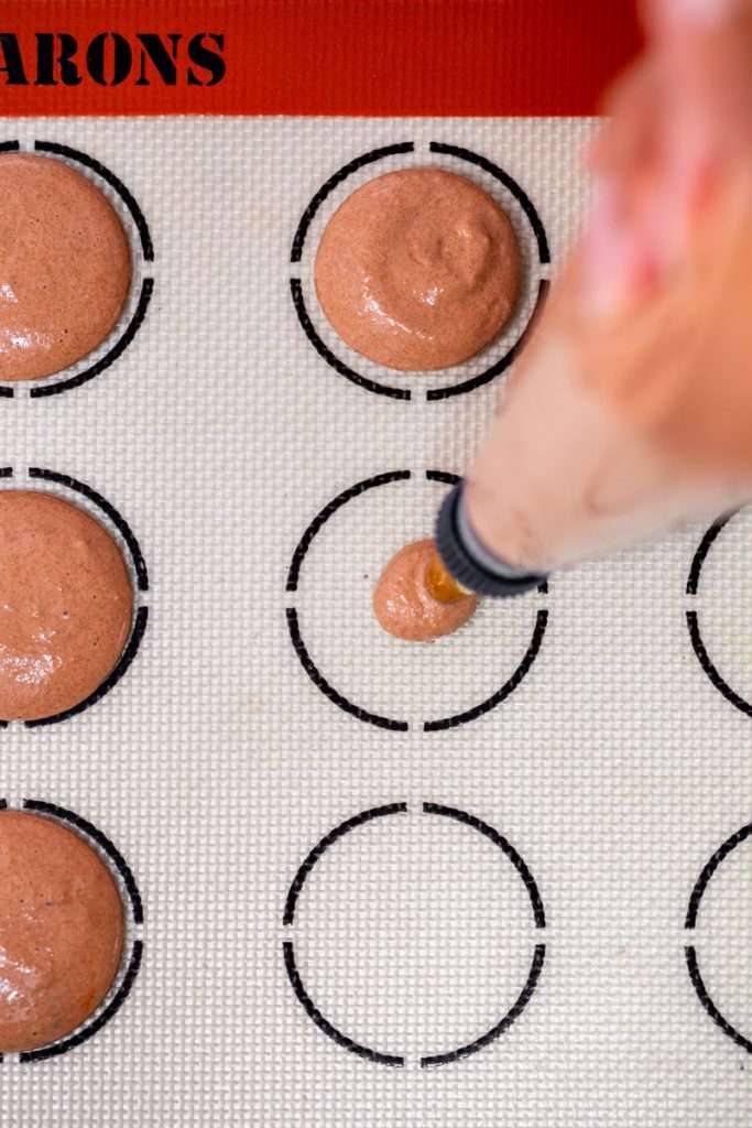 Don't let summer come to an end without making a batch of these S'mores macarons. Complete with chocolate macaron shells, homemade marshamallows, graham crackers and dark chocolate, they are the ultimate s'mores dessert for the season! Dairy free and gluten free option included.