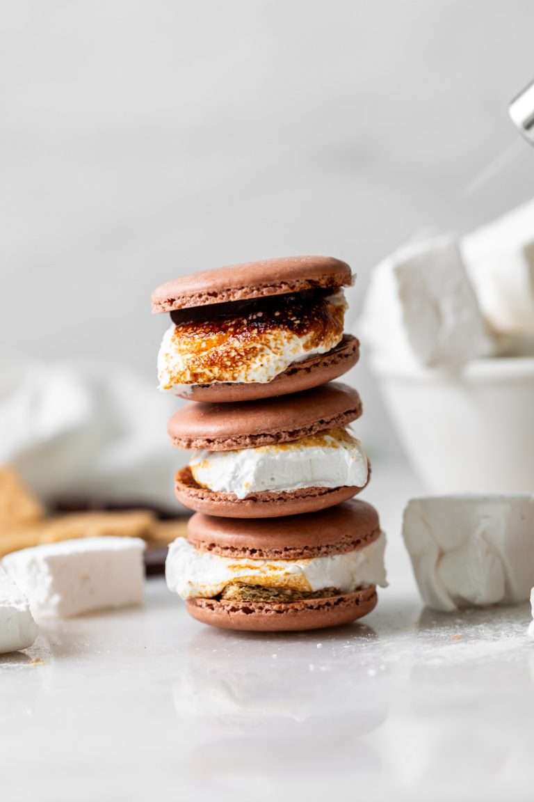 Don't let summer come to an end without making a batch of these S'mores macarons. Complete with chocolate macaron shells, homemade marshamallows, graham crackers and dark chocolate, they are the ultimate s'mores dessert for the season! Dairy free and gluten free option included.