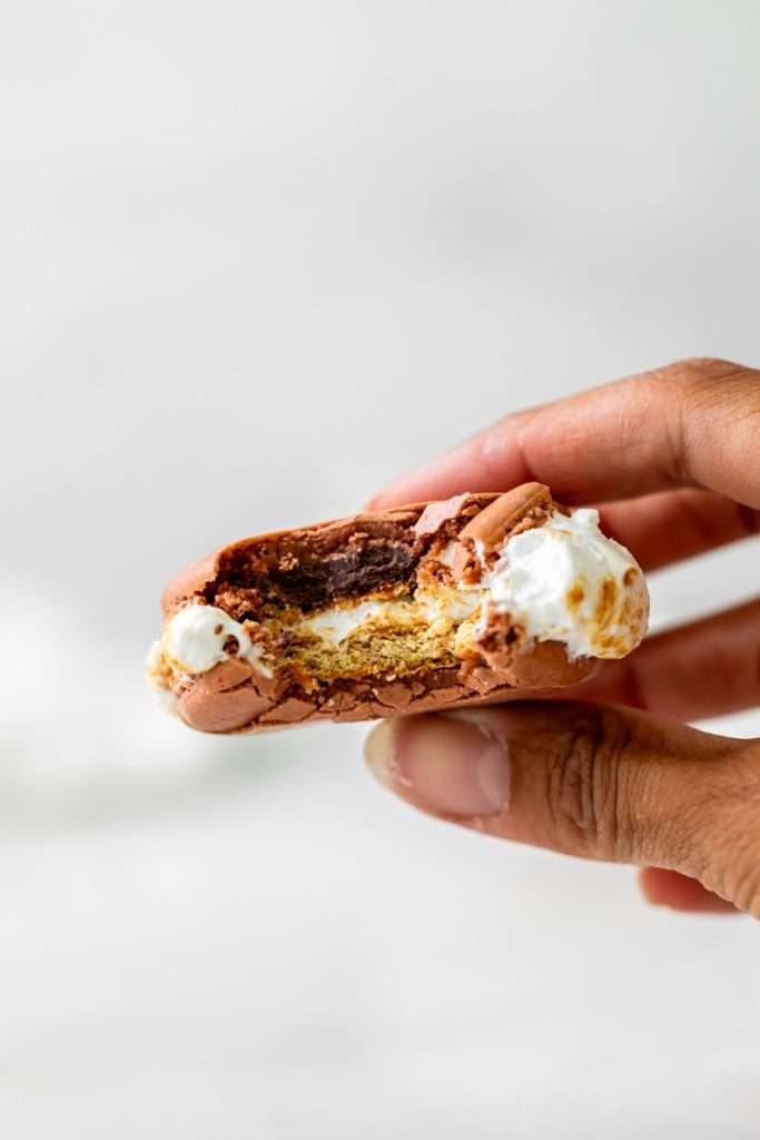 Don't let summer come to an end without making a batch of these S'mores macarons. Complete with chocolate macaron shells, homemade marshamallows, graham crackers and dark chocolate, they are the ultimate s'mores dessert for the season! Dairy free and gluten free option included.