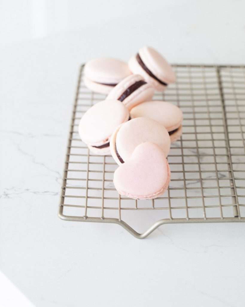 A photo of smooth elegant French macarons with clean feet, styled neatly by Posh Little Designs