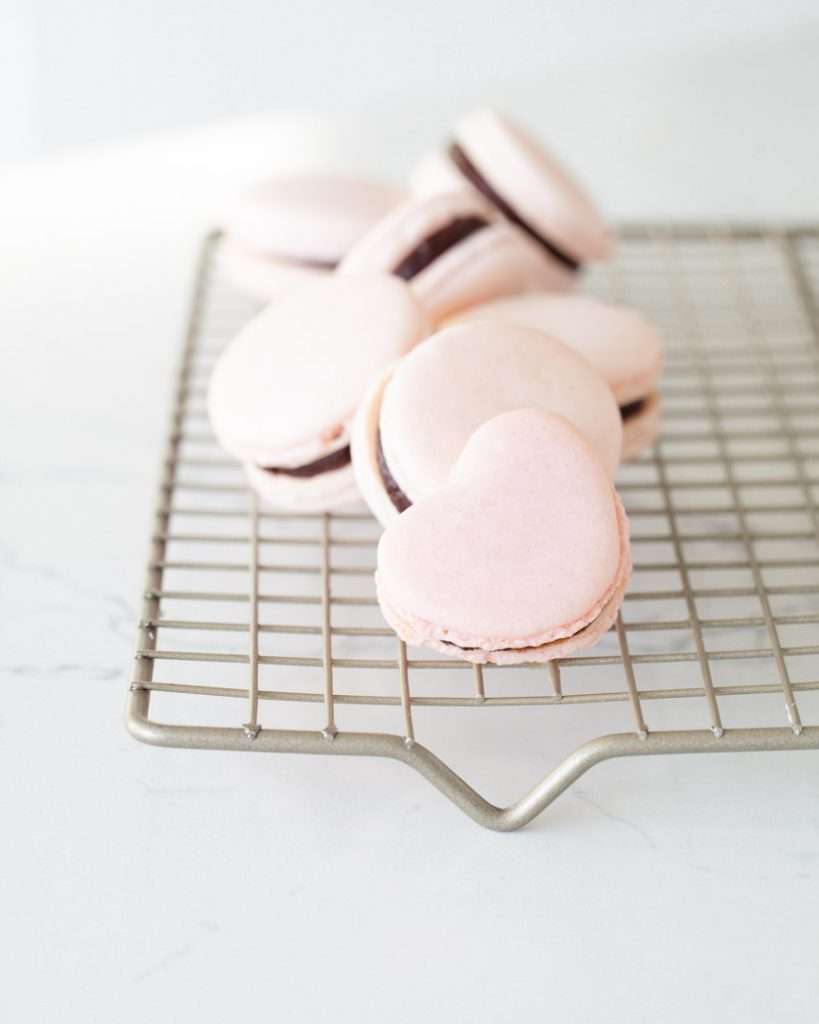 A photo of smooth elegant French macarons with clean feet, styled neatly by Posh Little Designs