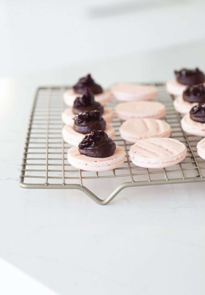 A photo of smooth elegant French macarons with clean feet, styled neatly by Posh Little Designs