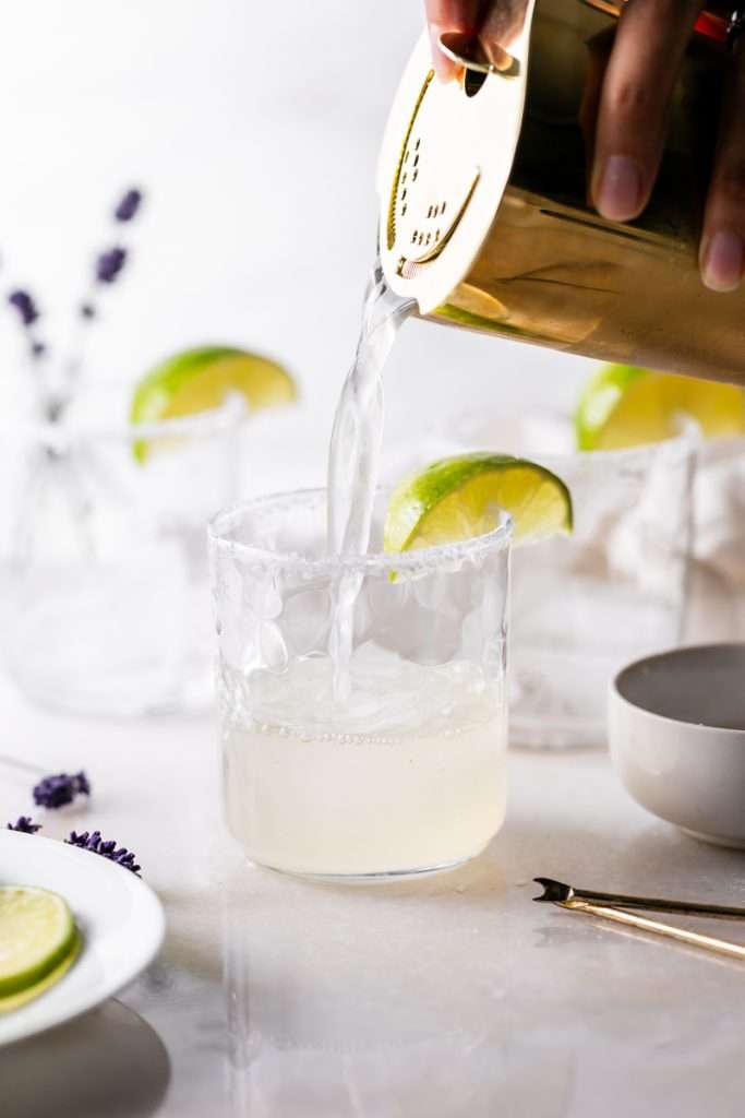 Easy homemade lavender margaritas recipe, complete with lavender simple syrup, fresh squeezed lime juice cointreau and tequila. Mix in advance and enjoy at your next summer gathering!