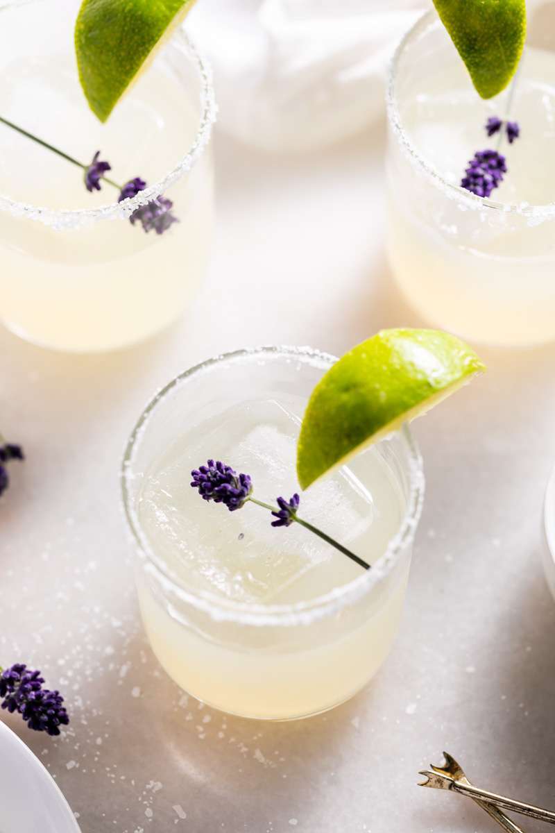 Easy homemade lavender margaritas recipe, complete with lavender simple syrup, fresh squeezed lime juice cointreau and tequila. Mix in advance and enjoy at your next summer gathering!