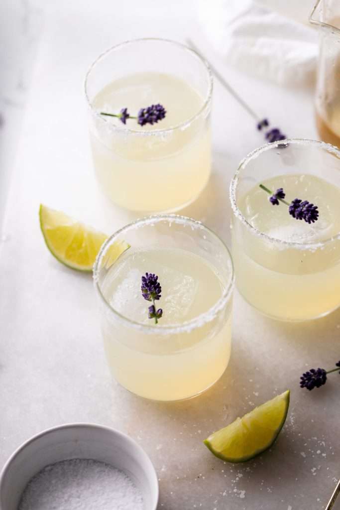 Easy homemade lavender margaritas recipe, complete with lavender simple syrup, fresh squeezed lime juice cointreau and tequila. Mix in advance and enjoy at your next summer gathering!