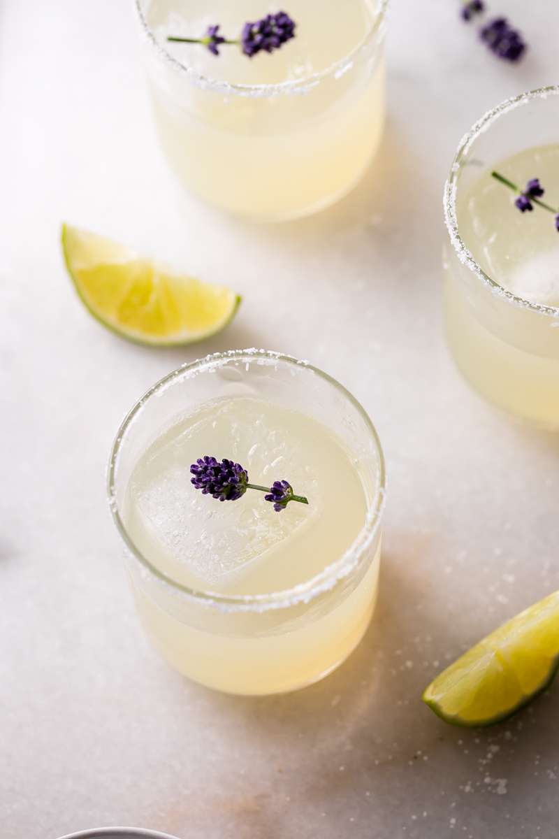 Easy homemade lavender margaritas recipe, complete with lavender simple syrup, fresh squeezed lime juice cointreau and tequila. Mix in advance and enjoy at your next summer gathering!