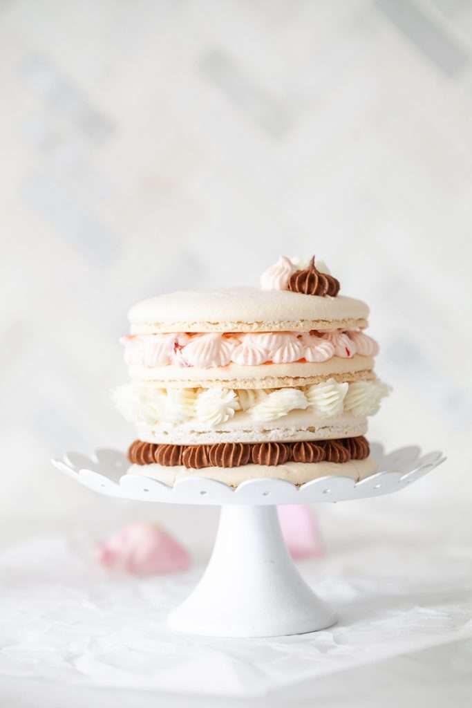 This sweet neapolitan macaron cake is made 5" in chewy macaron shells and filled with chocolate vanilla and strawberry frosting. Dairy & GF recipe and sweet treat to try this summer.