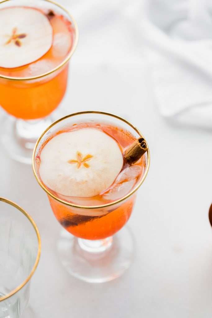 A mix of hard apple cider, Aperol and club soda garnished with cinnamon sticks and thinly sliced apple rounds, make up this light and refreshing twist on the classic Aperol Spritz. The perfect fall and autumn cocktail with warm spices. 
