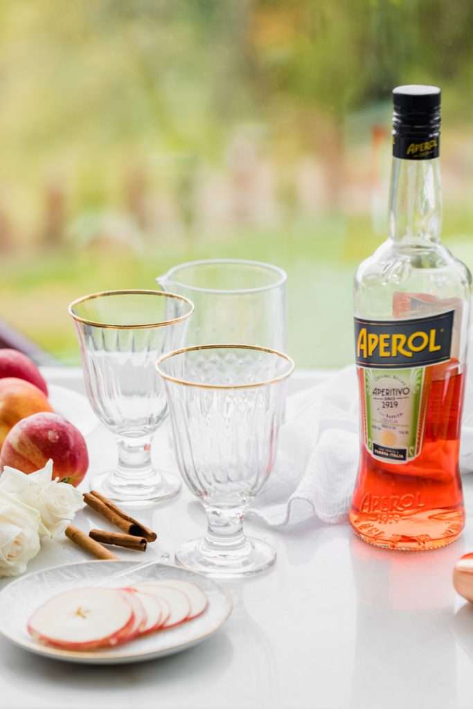 A mix of hard apple cider, Aperol and club soda garnished with cinnamon sticks and thinly sliced apple rounds, make up this light and refreshing twist on the classic Aperol Spritz. The perfect fall and autumn cocktail with warm spices. 