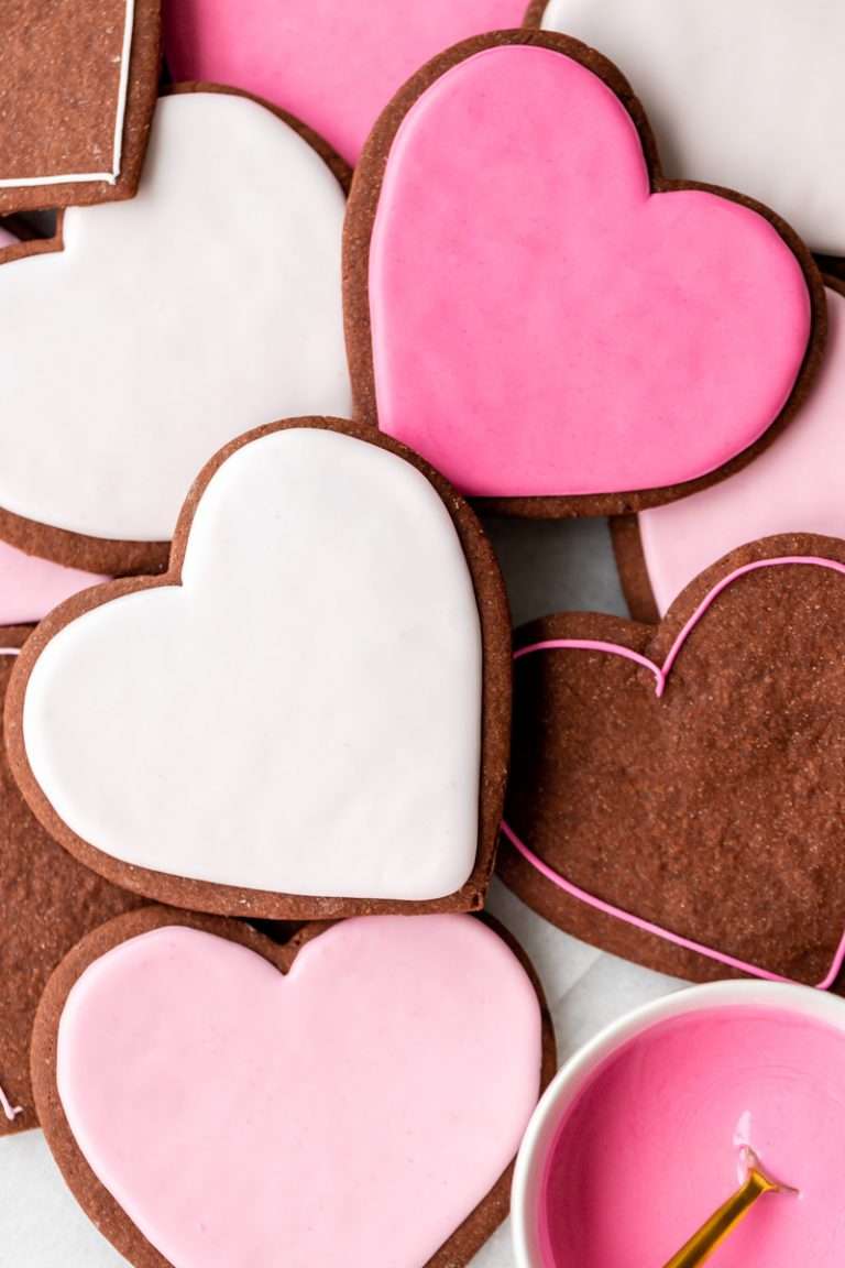Soft and delicious chocolate cutout sugar cookies decorated with vanilla royal icing. Recipe and decorating video. Perfect for Valentine's Day