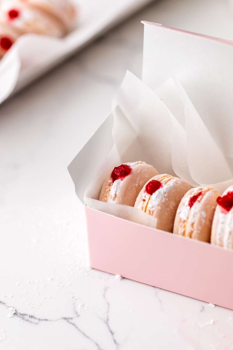jelly donut flavored French macarons made with donut frosting, homemade raspberry jam and confectioner's sugar