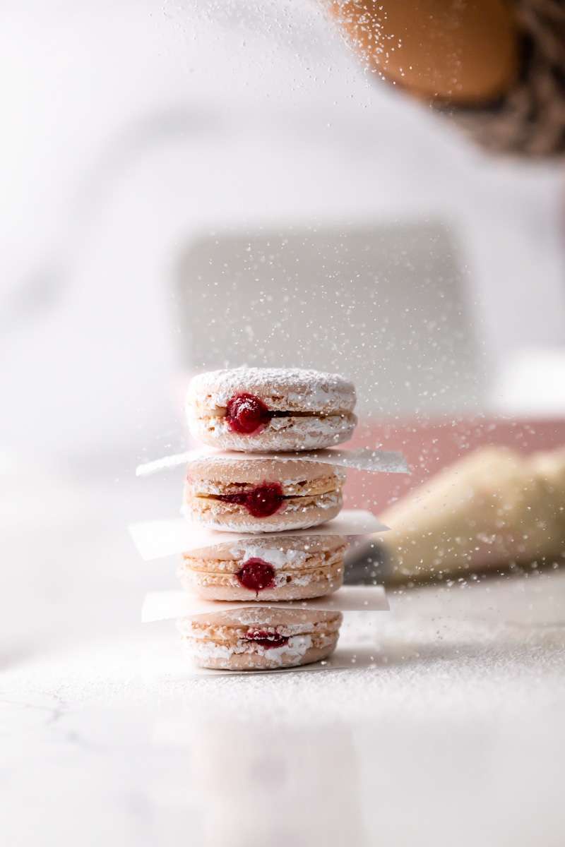jelly donut flavored French macarons made with donut frosting, homemade raspberry jam and confectioner's sugar