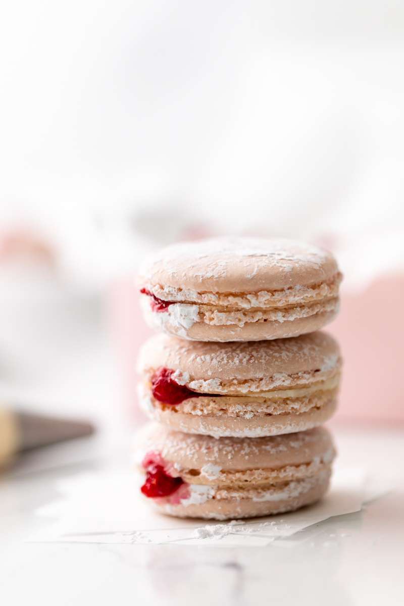 jelly donut flavored French macarons made with donut frosting, homemade raspberry jam and confectioner's sugar