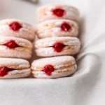 jelly donut flavored French macarons made with donut frosting, homemade raspberry jam and confectioner's sugar