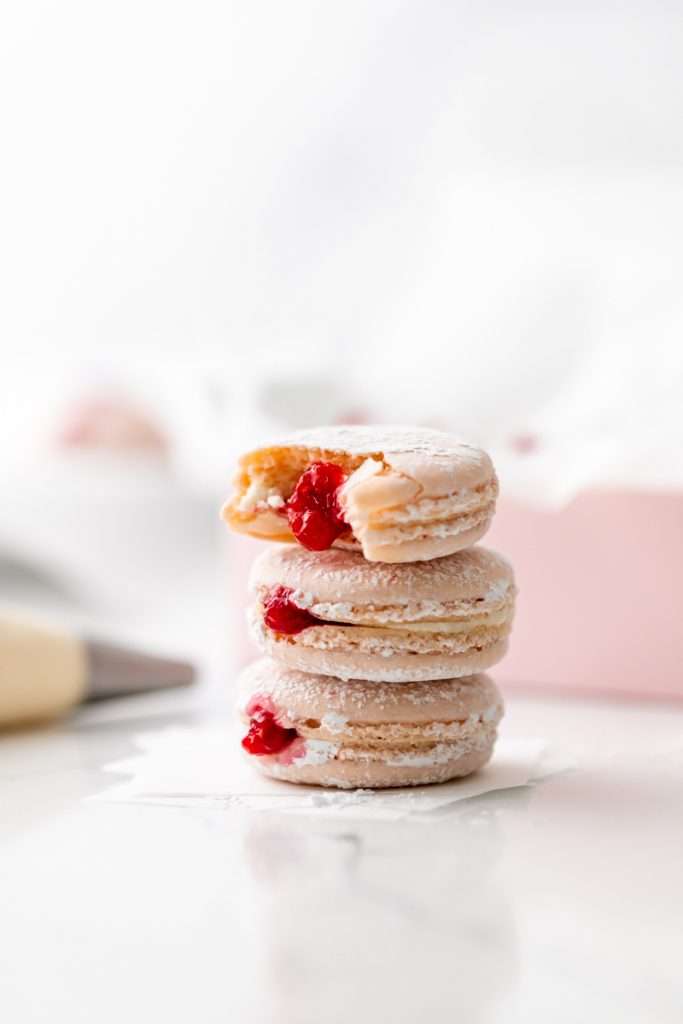 jelly donut flavored French macarons made with donut frosting, homemade raspberry jam and confectioner's sugar