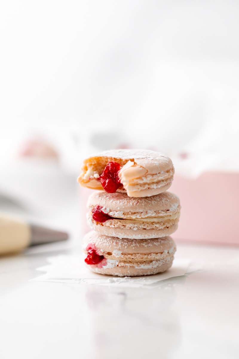 jelly donut flavored French macarons made with donut frosting, homemade raspberry jam and confectioner's sugar