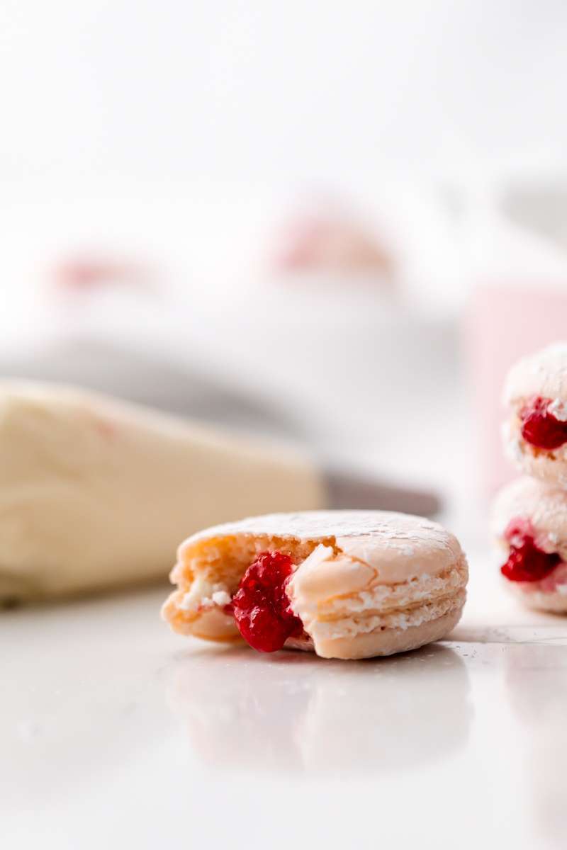 jelly donut flavored French macarons made with donut frosting, homemade raspberry jam and confectioner's sugar