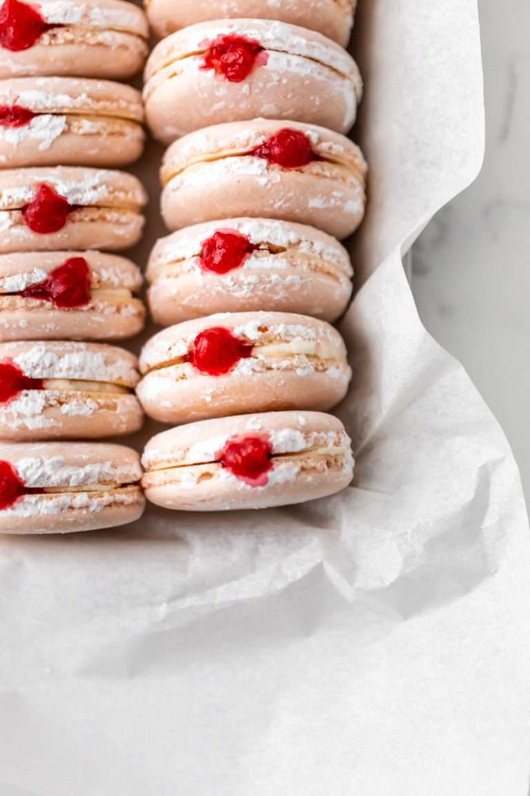 jelly donut flavored French macarons made with donut frosting, homemade raspberry jam and confectioner's sugar