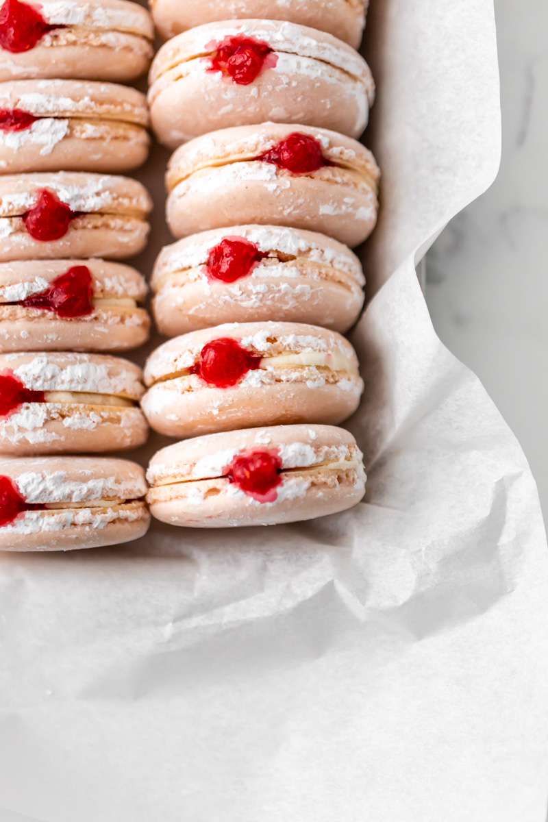 jelly donut flavored French macarons made with donut frosting, homemade raspberry jam and confectioner's sugar