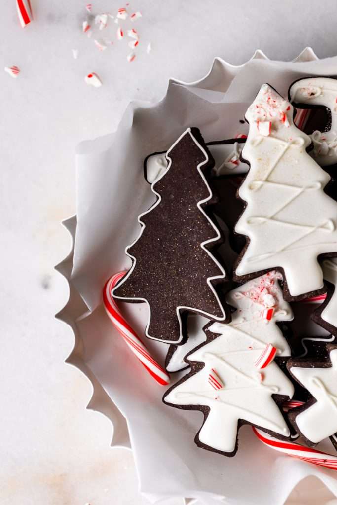 These peppermint black cocoa sugar cookies are rich, chocolatey and perfectly festive for the holidays. Made with rich black cocoa powder and a dash of peppermint they are ideal for Christmas cookies boxes and festive winter baking. Decorate with royal icing and crushed peppermint for a festive and delicious finish.