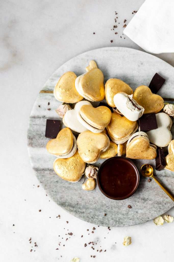 Heart macarons filled with hazelnut Nutella dark chocolate ganache, for Valentine's Day. Dairy and gluten free