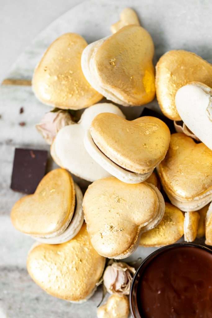 Heart macarons filled with hazelnut Nutella dark chocolate ganache, for Valentine's Day. Dairy and gluten free