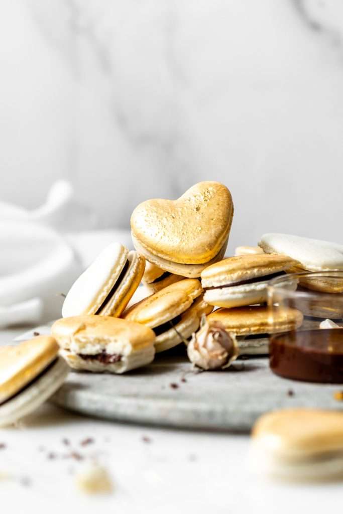 Heart macarons filled with hazelnut Nutella dark chocolate ganache, for Valentine's Day. Dairy and gluten free