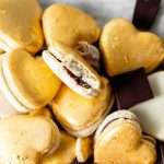Heart macarons filled with hazelnut Nutella dark chocolate ganache, for Valentine's Day. Dairy and gluten free
