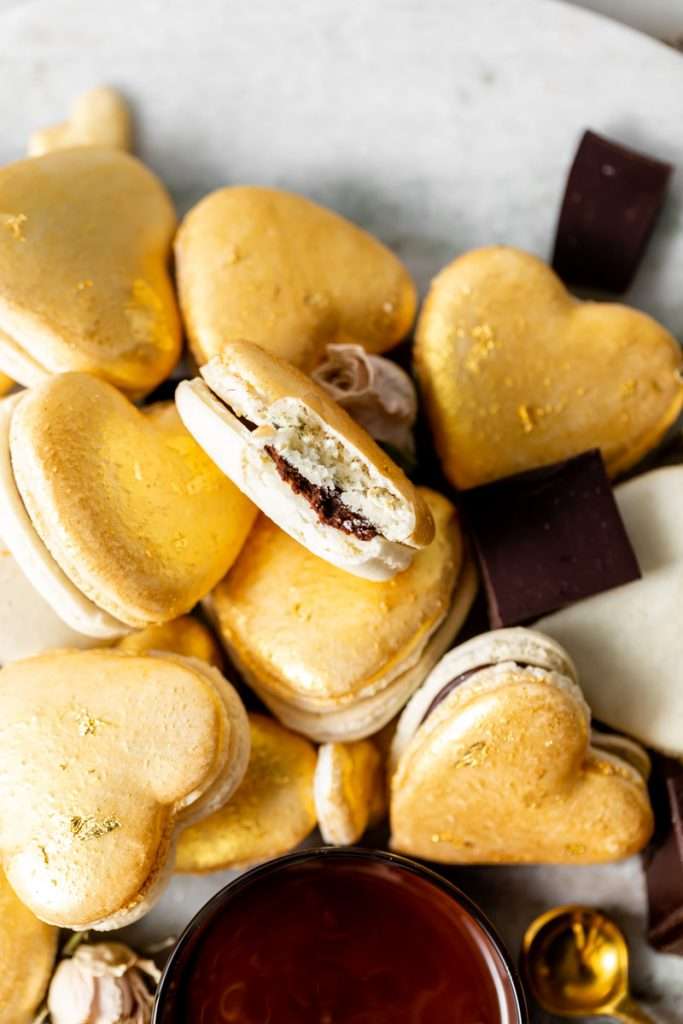 Heart macarons filled with hazelnut Nutella dark chocolate ganache, for Valentine's Day. Dairy and gluten free