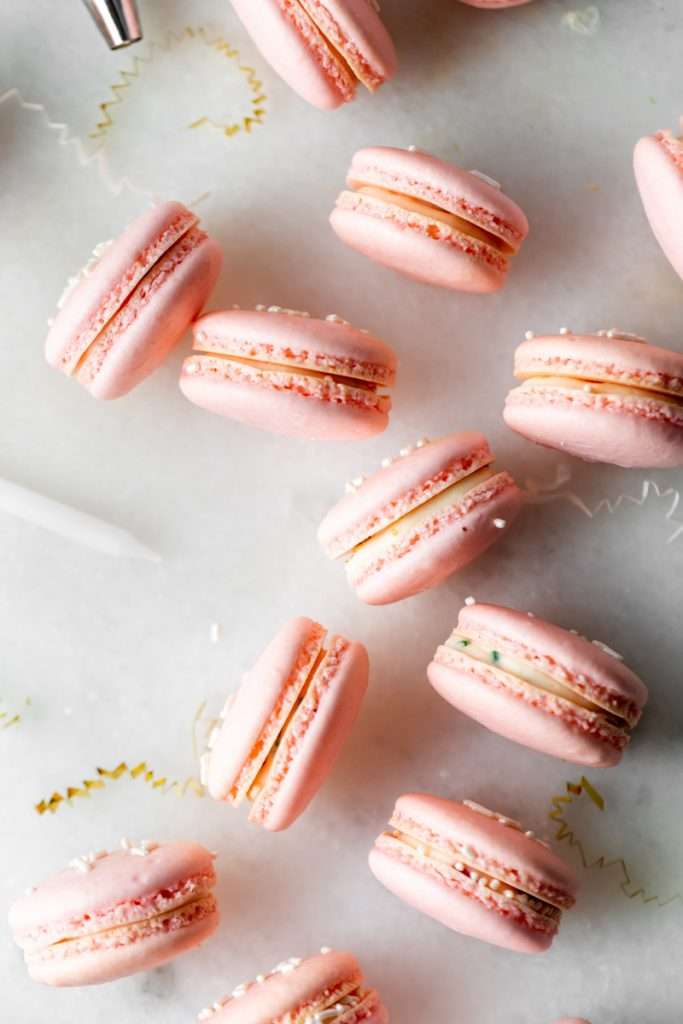 how to make birthday cake French macarons, filled with rainbow sprinkle frosting and rainbow cake crumbs. Dairy free & gluten free