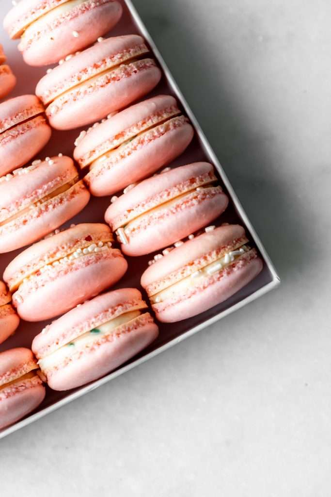 how to make birthday cake French macarons, filled with rainbow sprinkle frosting and rainbow cake crumbs. Dairy free & gluten free