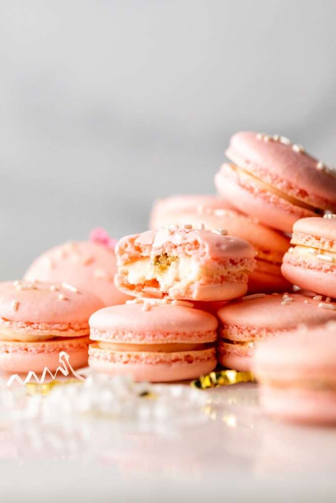 how to make birthday cake French macarons, filled with rainbow sprinkle frosting and rainbow cake crumbs. Dairy free & gluten free