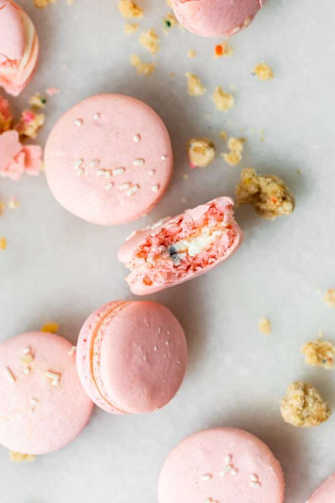 how to make birthday cake French macarons, filled with rainbow sprinkle frosting and rainbow cake crumbs. Dairy free & gluten free