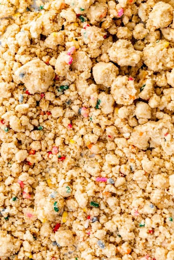 how to make birthday cake French macarons, filled with rainbow sprinkle frosting and rainbow cake crumbs. Dairy free & gluten free