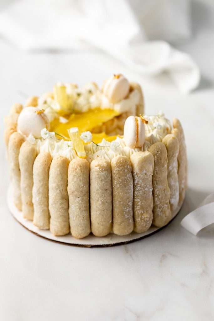 A bright and cheery lemon Charlotte cake, made with 4" macaron shells in place of sponge. Filled with lemon frosting and lemon curd. Dairy and gluten free.