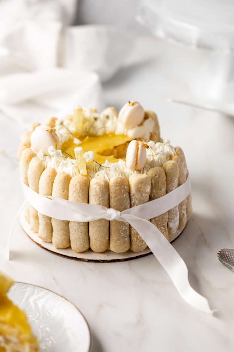 A bright and cheery lemon Charlotte cake, made with 4" macaron shells in place of sponge. Filled with lemon frosting and lemon curd. Dairy and gluten free.