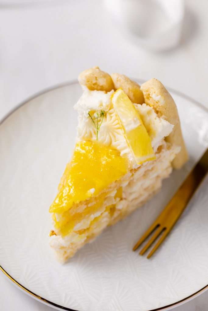A bright and cheery lemon Charlotte cake, made with 4" macaron shells in place of sponge. Filled with lemon frosting and lemon curd. Dairy and gluten free.