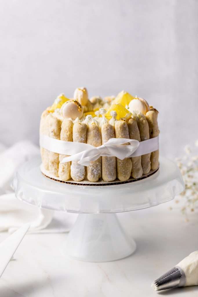 A bright and cheery lemon Charlotte cake, made with 4" macaron shells in place of sponge. Filled with lemon frosting and lemon curd. Dairy and gluten free.