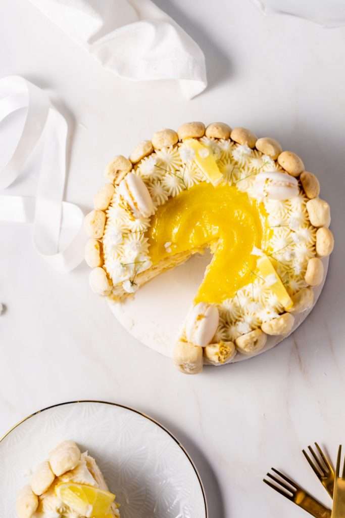 A bright and cheery lemon Charlotte cake, made with 4" macaron shells in place of sponge. Filled with lemon frosting and lemon curd. Dairy and gluten free.