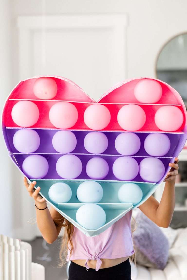 DIY giant pop-it party decor made from balloons and foam board
