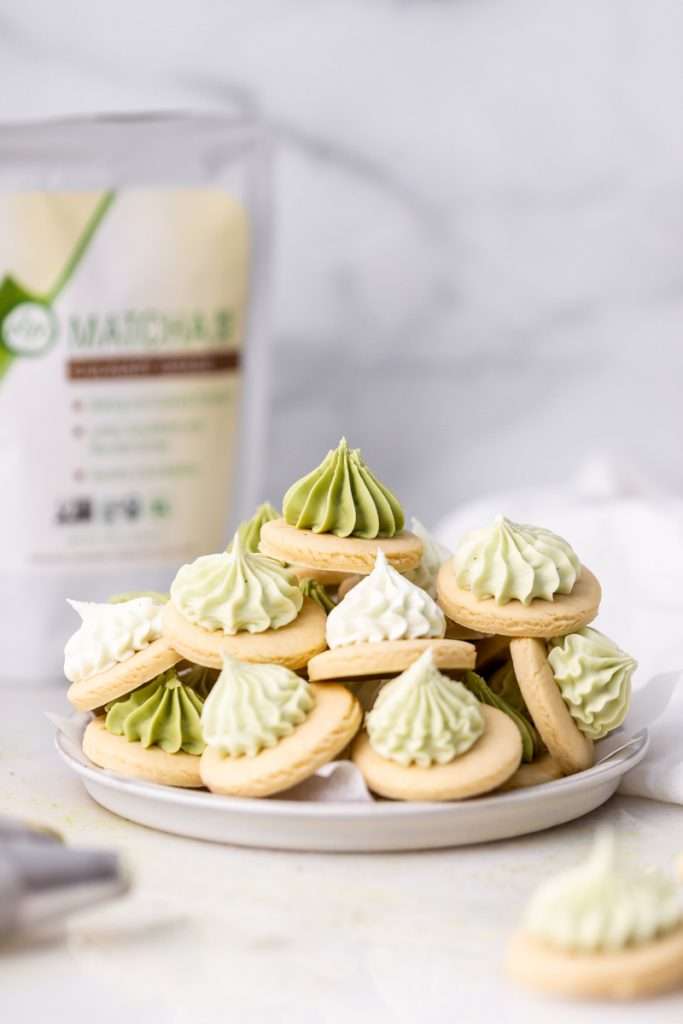 Matcha iced sugar cookies stacked on a plate. The perfect bite sized fall treat!
