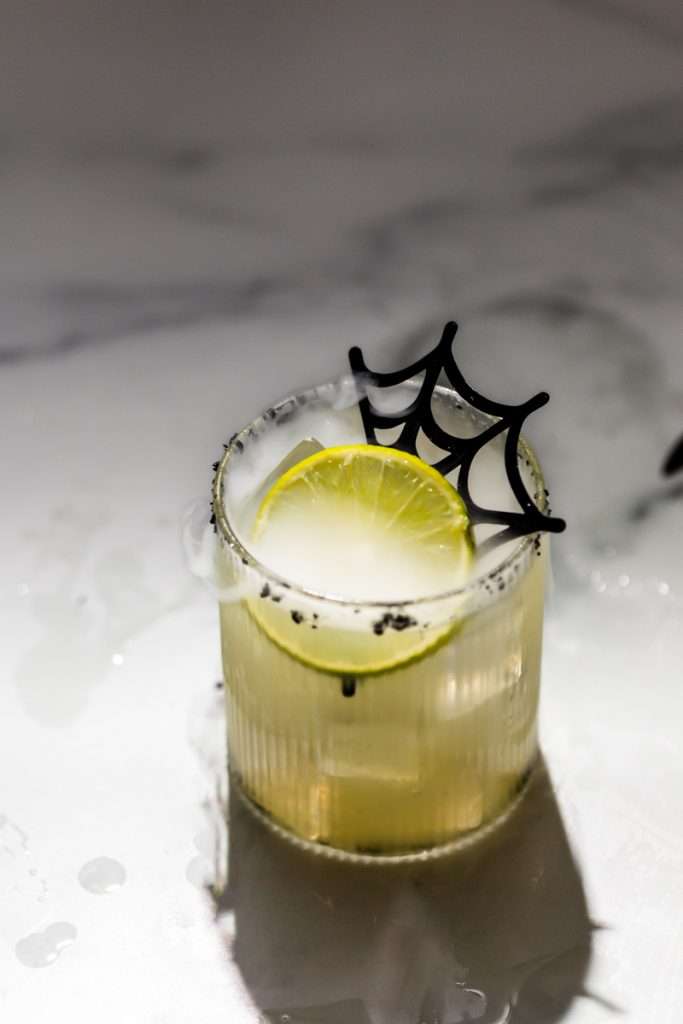 A quick and easy smoked margarita recipe perfect for halloween, made with mezcal and served on the rocks!