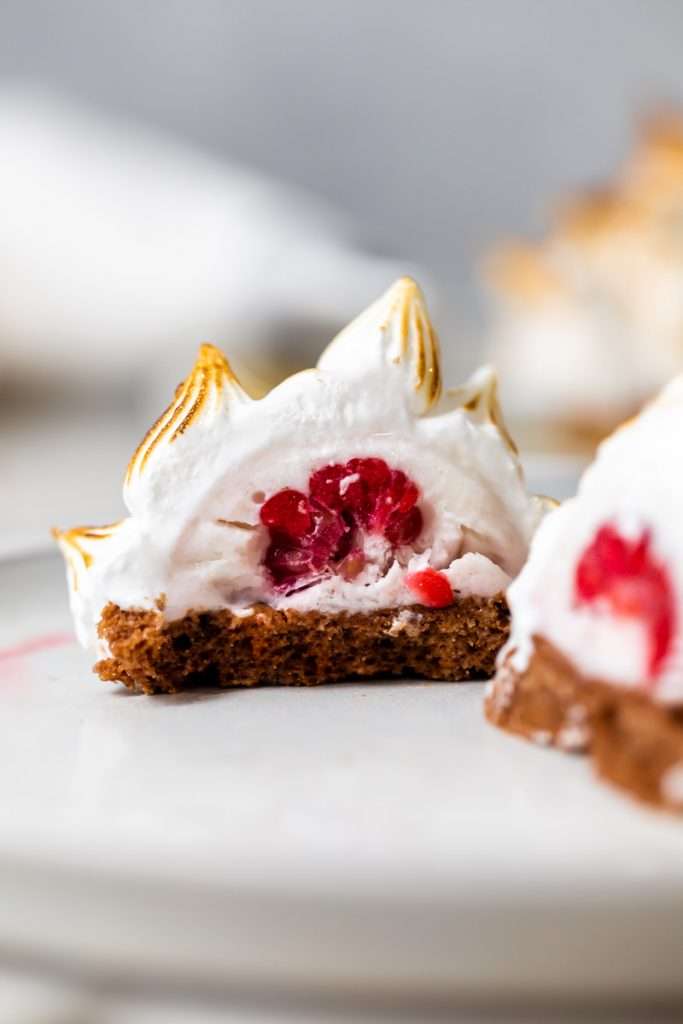 Baked Alaska Macarons, with a chocolate macaron shell base, raspberry ice cream core, topped with torched Italian meringue. A modern bite-sized spin on the classic Baked Alaska dessert. Dairy Free & Gluten Free