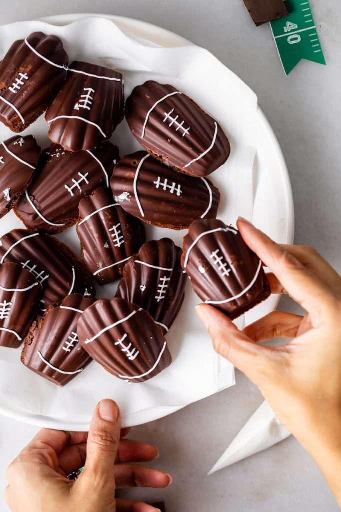 A recipe for chocolate French madeleines, coated in dark chocolate and decorated to look like footballs for Super Bowl Sunday or any football theme. Dairy and Gluten free option