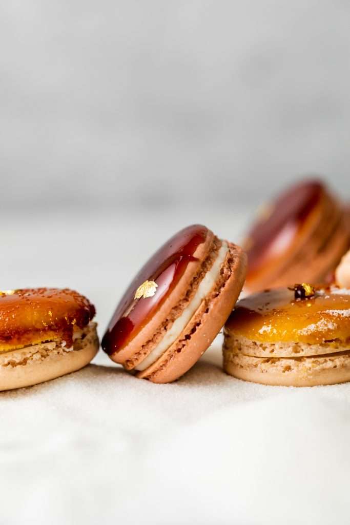 Créme brûlée macarons recipe inspired by trendy crème brûlée donuts, complete with a creamy vanilla custard center and a crisp caramelized sugar dipped shell. A dairy free and gluten free macaron recipe. Enjoy with tea, coffee, or champagne!