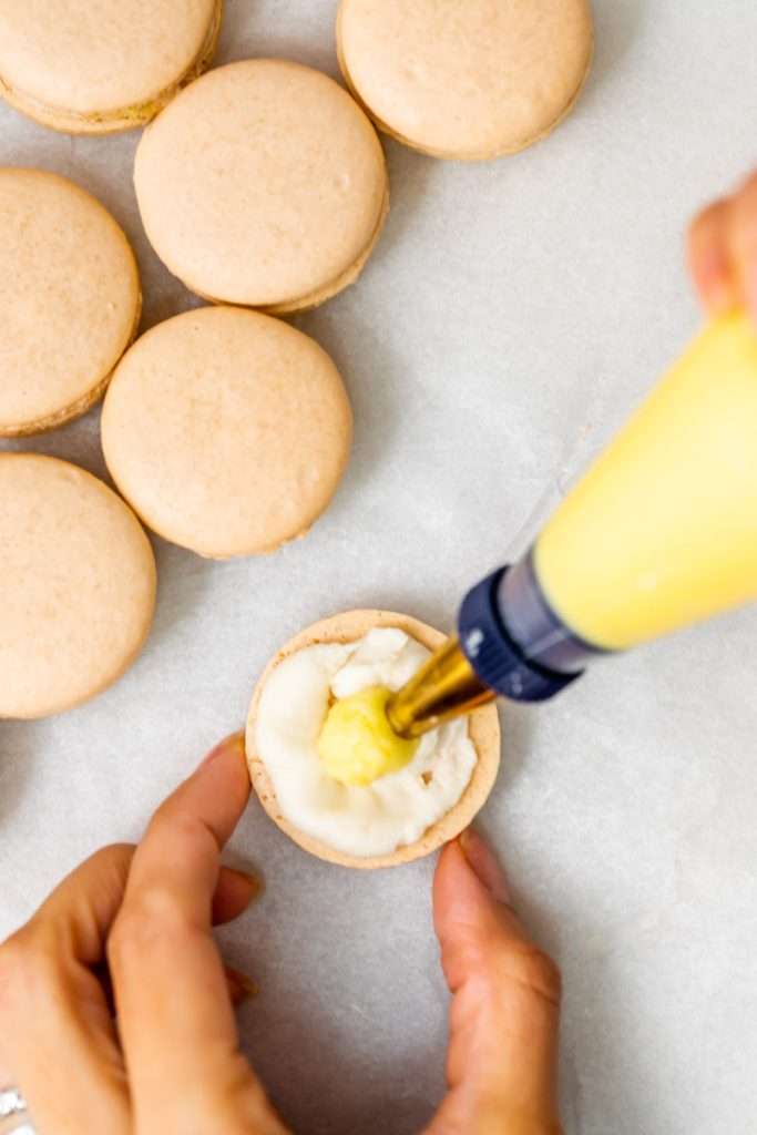 Créme brûlée macarons inspired by trendy crème brûlée donuts, complete with a creamy vanilla custard center and a crisp caramelized dipped shell. A dairy free and gluten free macaron recipe. Enjoy with tea, coffee, or champagne.